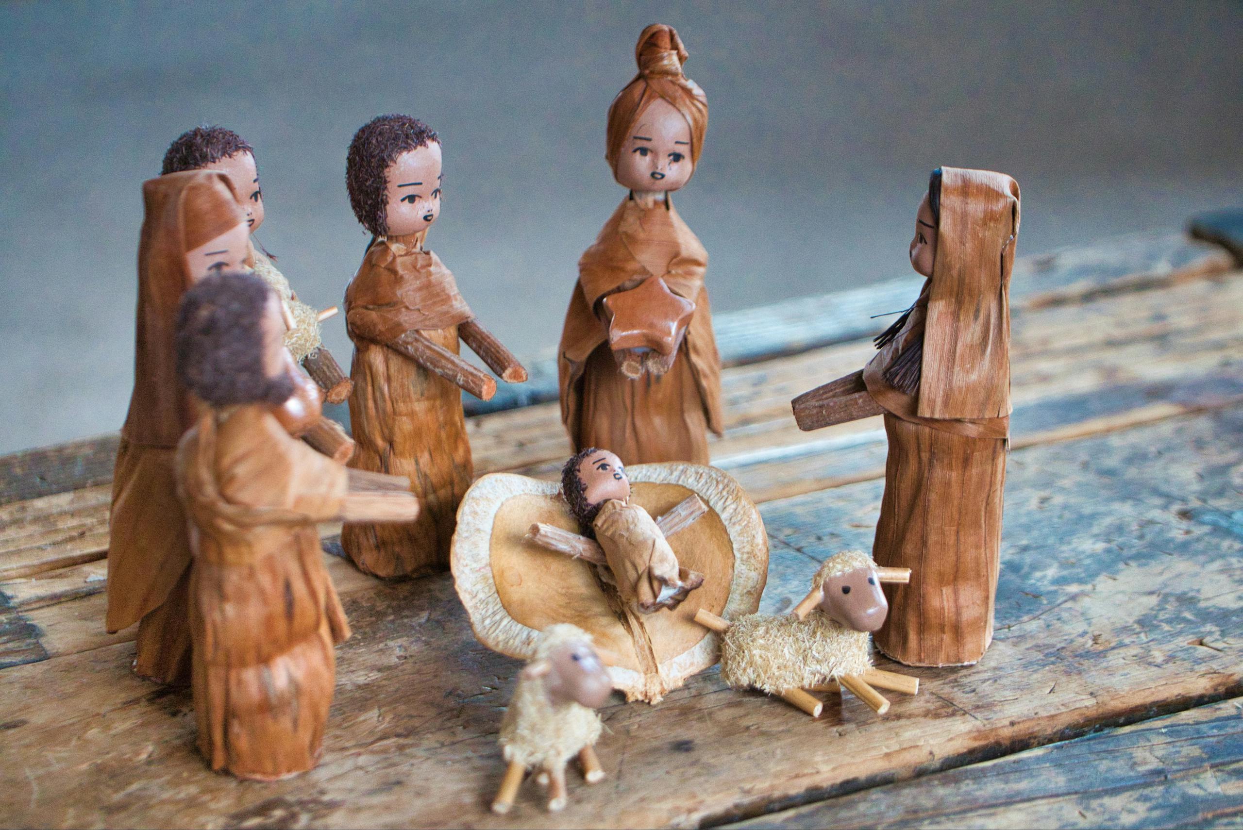 Charming handmade nativity scene depicting Baby Jesus, Mary, and others in a traditional wooden style.
